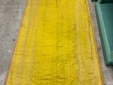 une couverture jaune posée par terre à côté d'une chaise verte