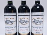 trois bouteilles de vin rouge posées l'une à côté de l'autre sur une surface blanche