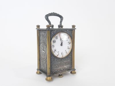 a small clock that is sitting on a white surface