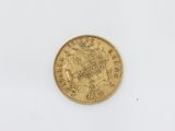 a close up of a gold coin on a white surface