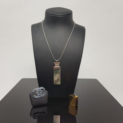 necklace, bracelet, and lighter on display on a black table