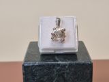 silver plated ring with a flower on top of a black marble block