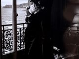 une photo en noir et blanc d'une femme assise devant une fenêtre