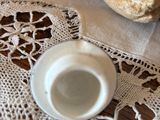 a cup of coffee on a doily with a rock in the background