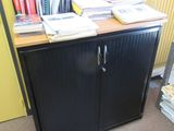 a black cabinet with books on top of it in a room
