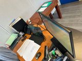une personne assise à un bureau, devant un ordinateur et un clavier