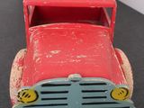a red toy truck with a smiley face on the front