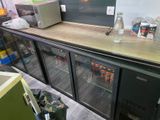 a counter with a refrigerator and some drinks on it