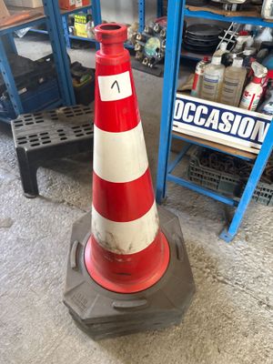 un cône de signalisation rouge et blanc dans un garage