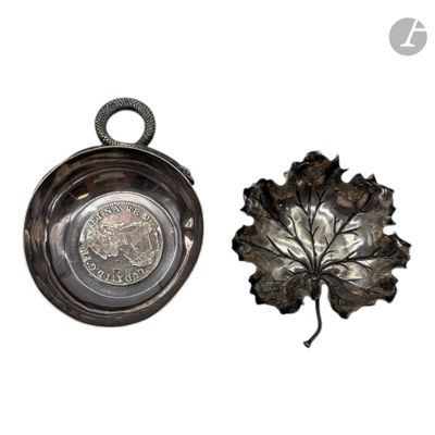 une assiette en argent ornée d'une feuille, posée à côté d'un bol en argent