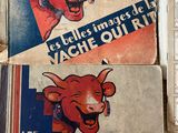 three books on a table with a red cow on it