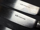 three knives that are sitting on top of a table