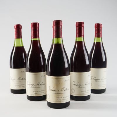 quatre bouteilles de vin sont alignées sur une surface blanche