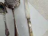 a knife, spoon, and spoon rest on a piece of paper