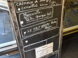 un tableau noir sur lequel est inscrit le menu, devant un comptoir