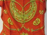 une écharpe orange ornée d'un motif doré et rouge