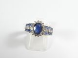 gros plan d'une bague en saphir bleu et diamant sur une surface blanche