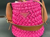 a close up of a pink handbag with a brown strap