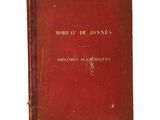 an old book with a red cover sitting on top of a white surface