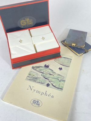 a book and a pair of earrings sitting on a table