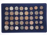 a blue tray filled with lots of coins sitting on top of a white surface