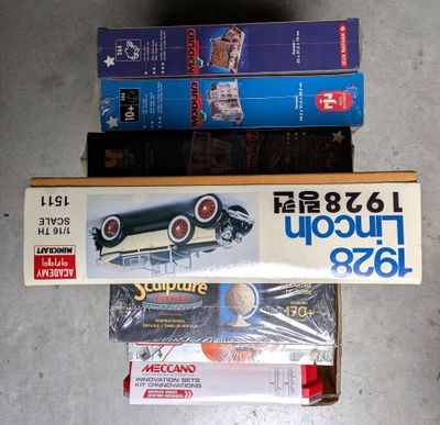three boxes of model cars sitting on the floor