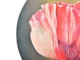 a painting of a pink flower on a black plate