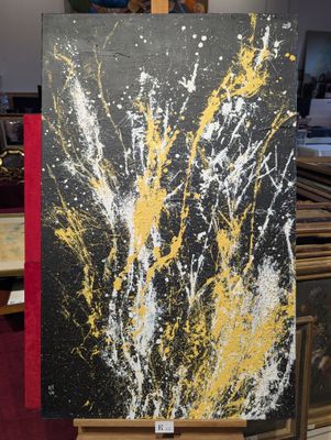 de la peinture jaune et noire éclaboussée sur une toile posée sur un chevalet en bois