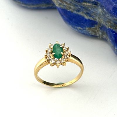 an image of a gold ring with a green stone on it