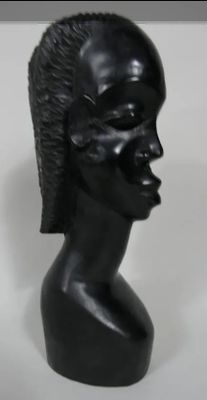 sculpture représentant une tête d'homme coiffée d'une crête iroquoise sur fond blanc
