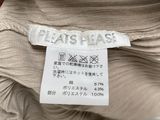 a close up of a white label on a beige sweater