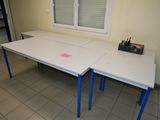 une table blanche avec des pieds bleus et un autocollant rose dessus