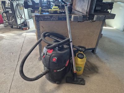 un aspirateur posé sur le sol du garage