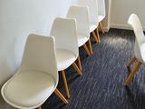several white chairs are lined up in a row in a room