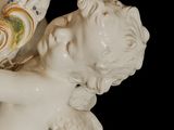 a statue of a cupid holding a bouquet of flowers