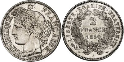 a silver coin with a woman ' s head and laurels on it