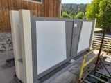 three refrigerators sitting on a rack outside of a building