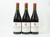 trois bouteilles de vin rouge posées sur une table blanche