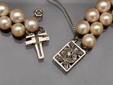pearl necklace with a cross and a cross pendant on it