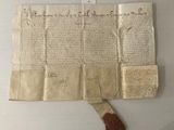 un vieux bout de papier sur lequel est posé un morceau de cire