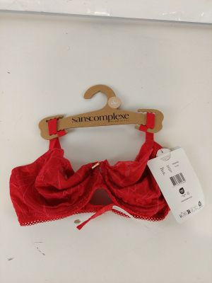 red lace bralette on a hanger with a price tag