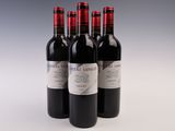 trois bouteilles de vin rouge posées sur une table blanche