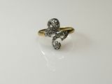a close up of a gold and diamond ring on a white surface