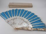 a blue and white fan with a wooden box in the background