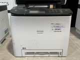 a printer that is sitting on the floor in front of a washing machine