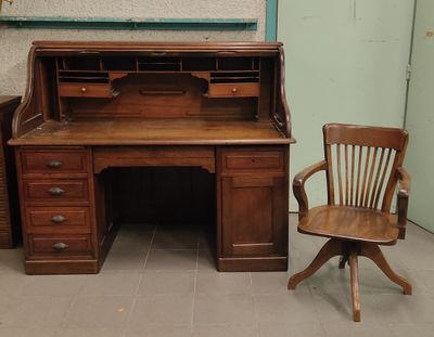 un bureau en bois avec une chaise à côté, dans une pièce