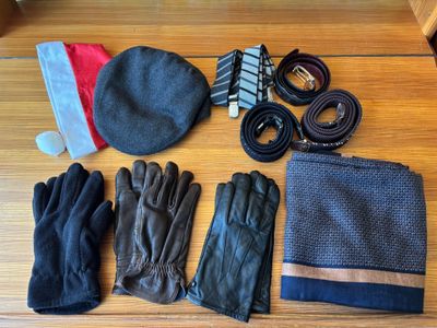 a hat, gloves, gloves, and other items laid out on a table