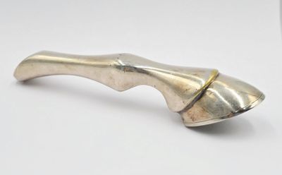 un petit objet argenté sur une surface blanche