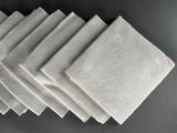 six white napkins are stacked on top of each other on a table