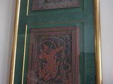 deux tableaux encadrés accrochés au mur au-dessus d'un vase